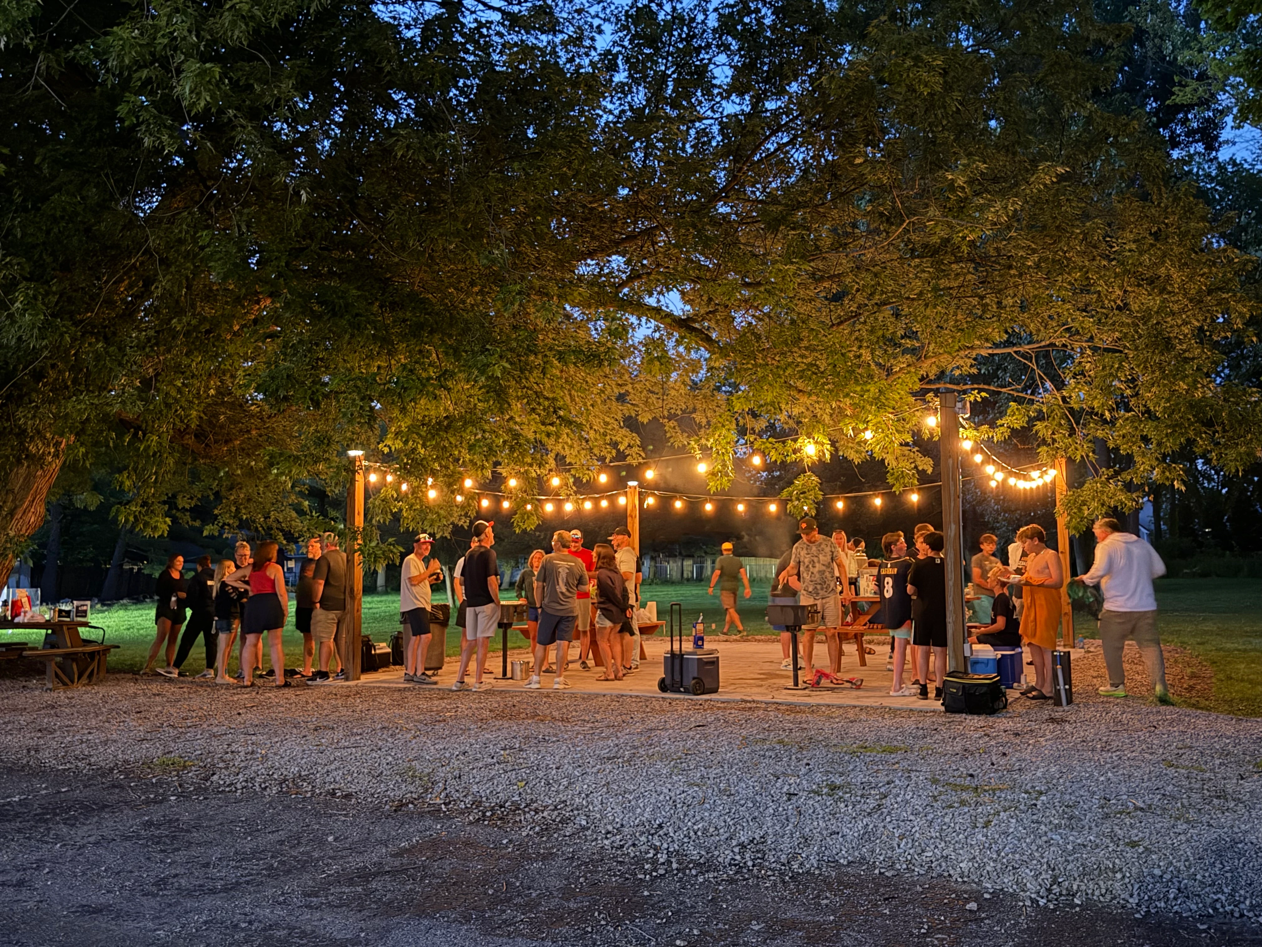 Group enjoying the BBQ patio area at South Shore Inn on a summer evening with string lights