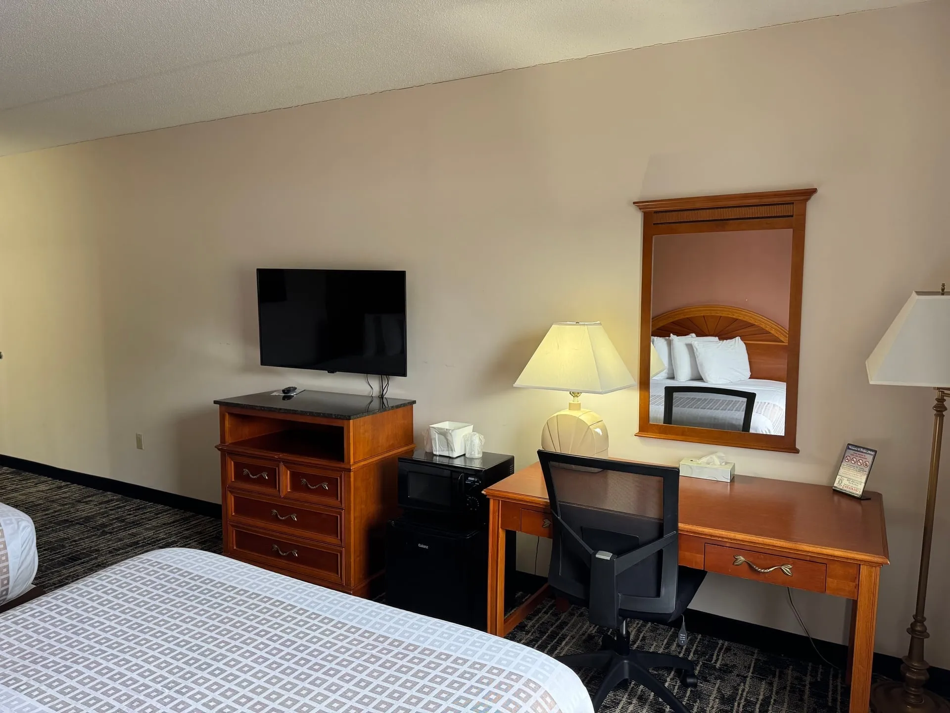 Queen room with desk, fridge, and microwave